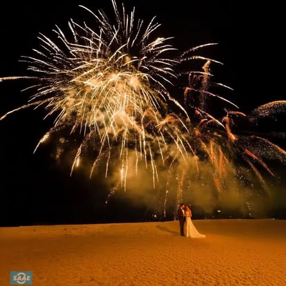 Fireworks above a couple on the beach, from the SAAE gallery